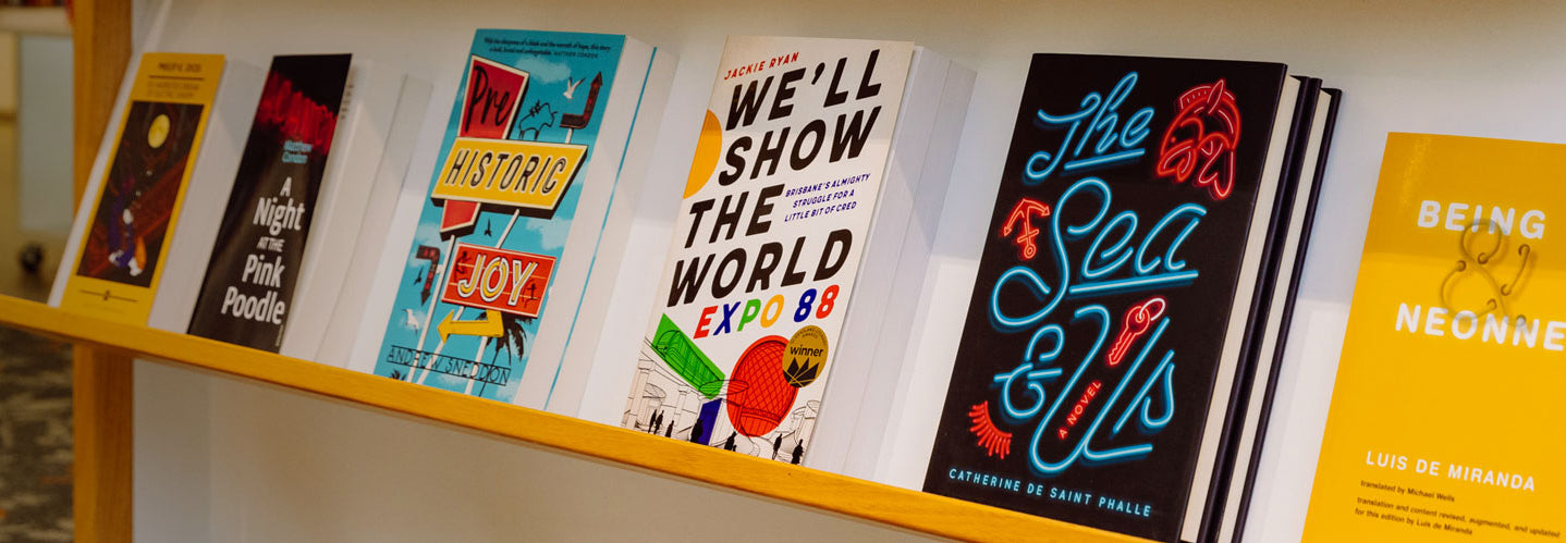 Shelf at the library shop with books about neon signs on it.